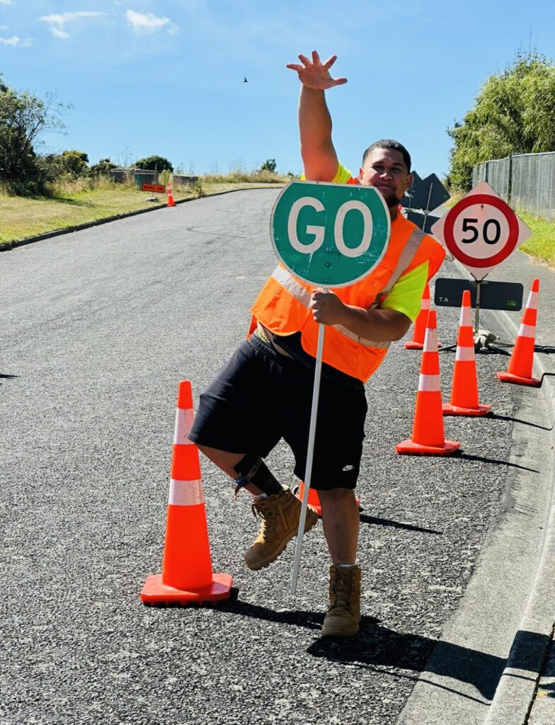 Traffic management staff member holding a GO sign