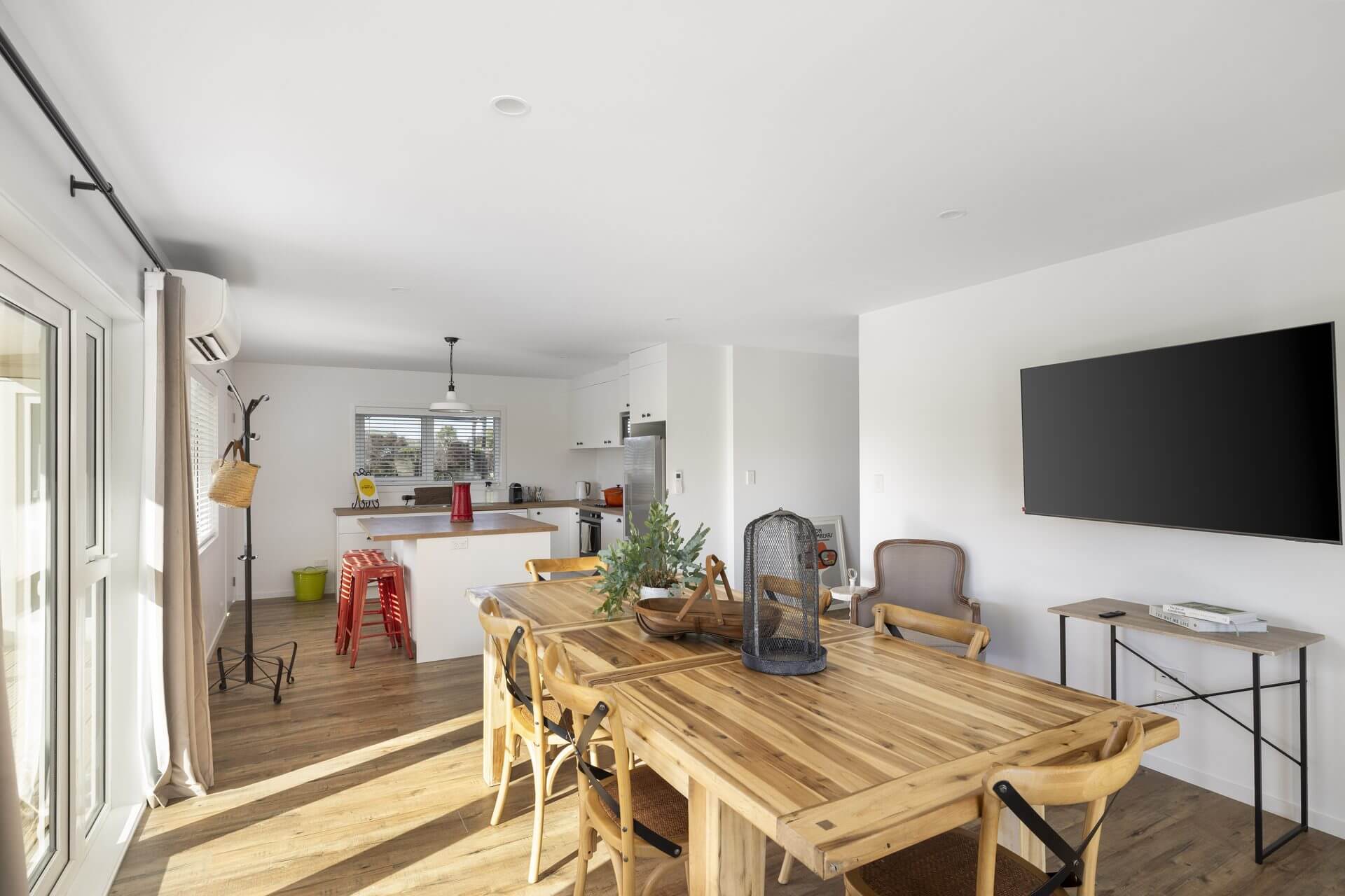 Renovated kitchen and dining area with white cabinetry, wooden Benchtops and wood floors