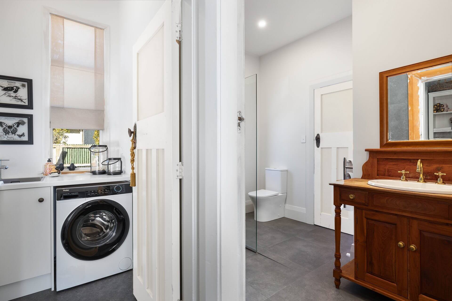 Character cottage bathroom laundry renovation with modern large black slate looking tiles and vintage vanity